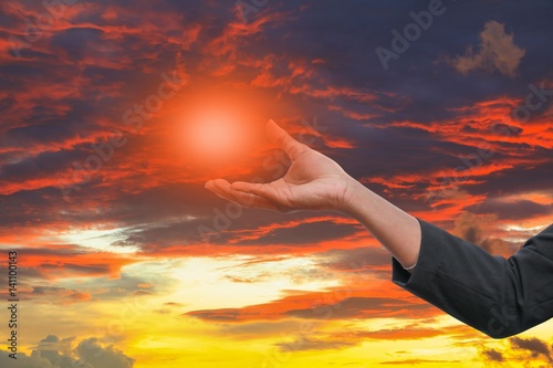business man receiving hand holding the light in  palm of  idea  on sky red  background © pramot48