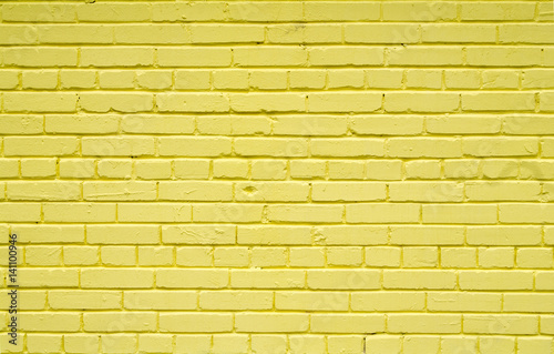 Old brick brick wall painted with yellow paint for textures or backgrounds photo