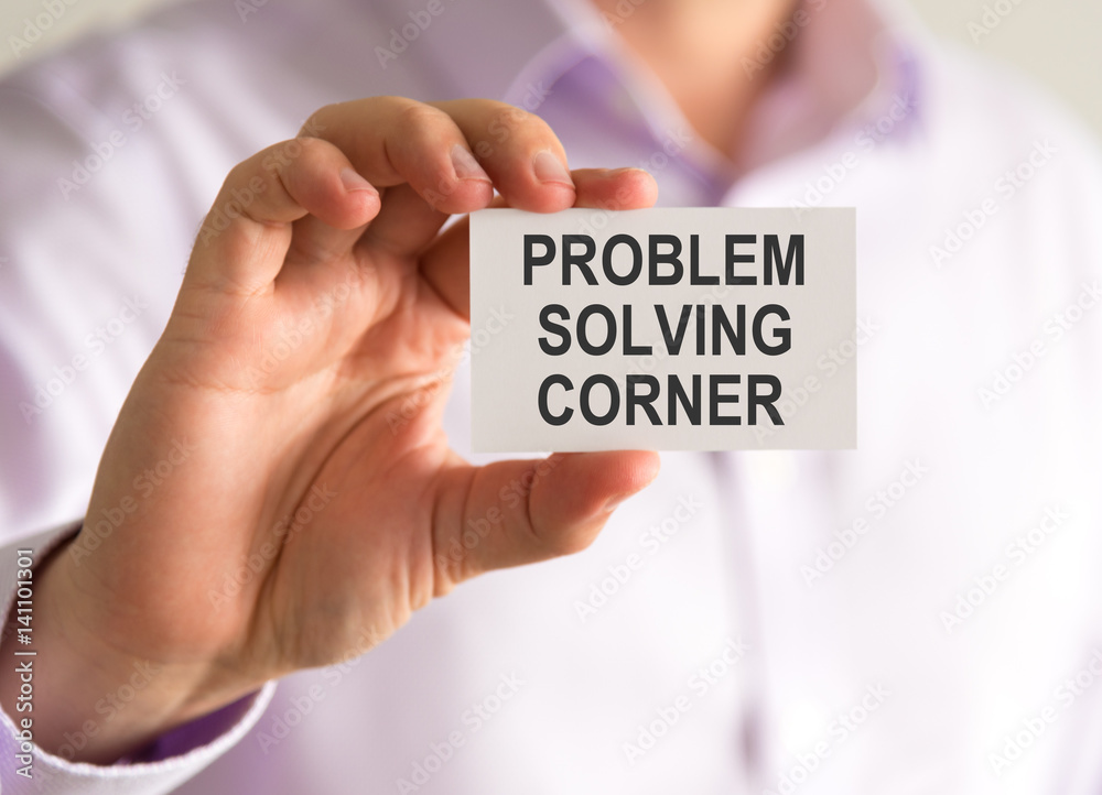 Businessman holding a card with PROBLEM SOLVING CORNER message Businessman holding a card with PROBLEM SOLVING CORNER message