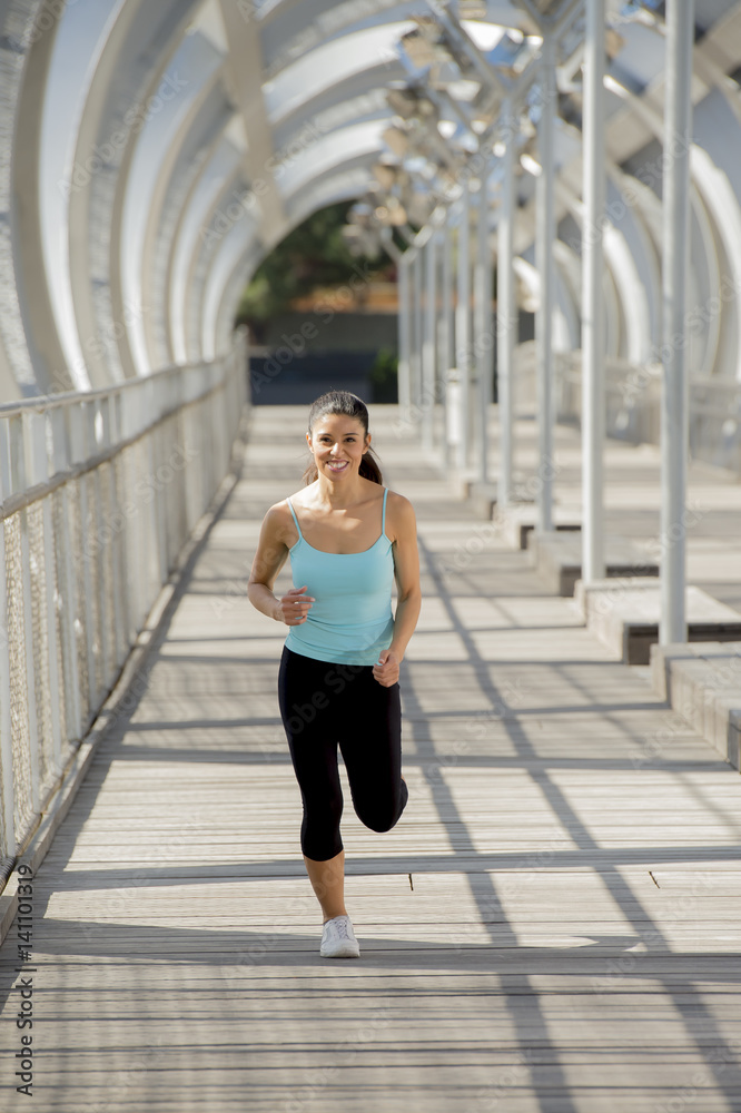 young beautiful athletic sport woman running and jogging crossing modern metal city bridge
