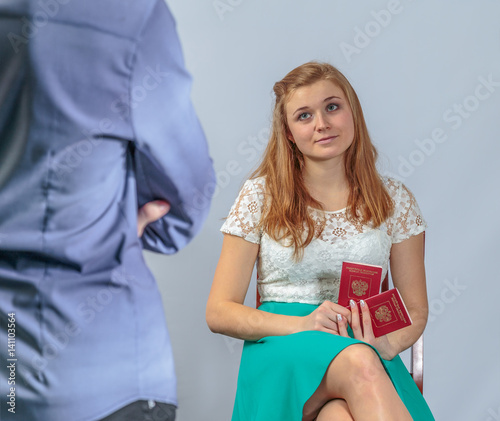 Girl and the guy posing in the studio with passports
