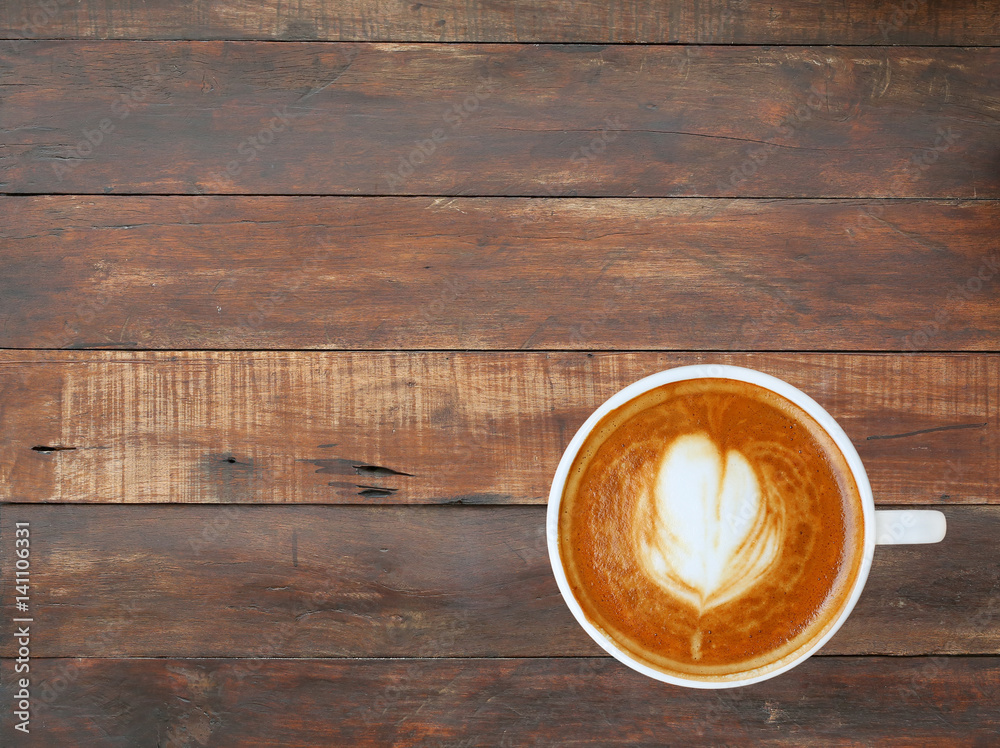Top view of a coffee with heart pattern in a white cup on wooden plank background, latte art Top view of a coffee with heart pattern in a white cup on wooden plank background, latte art