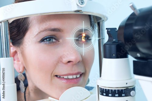 Checking eyesight in a clinic of the future, young girl. Ophthalmology. Future medicine and health concept. Virtual laser for checking vision.