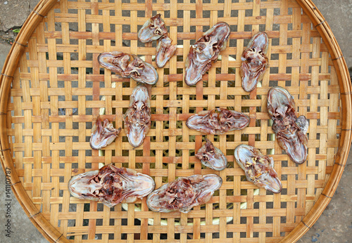 Dried head of a snakehead fish on bamboo weave photo