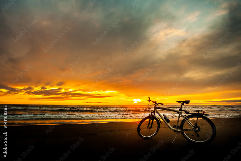 Fototapeta premium Tourist bike on the coast of the sea at sunset time