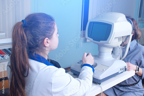 Checking eyesight in a clinic of the future, young girl. Ophthalmology. Future medicine and health concept. Virtual laser for checking vision.