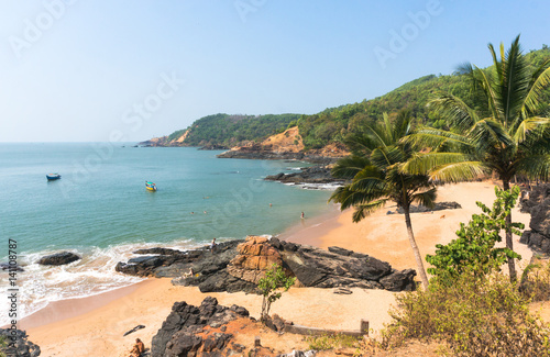 Paradise beach in Gokarna. Beautiful deserted landscape with clean sand and wave. View from the sea to the shore. photo