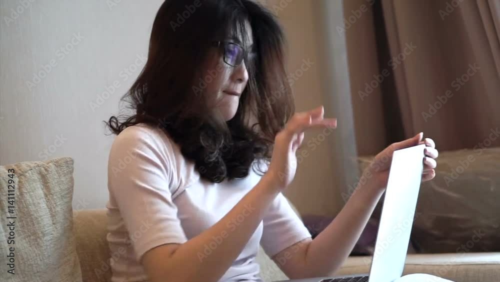 Angry frustrated Asian woman work from home using her laptop to check work email Angry frustrated Asian woman work from home using her laptop to check work email