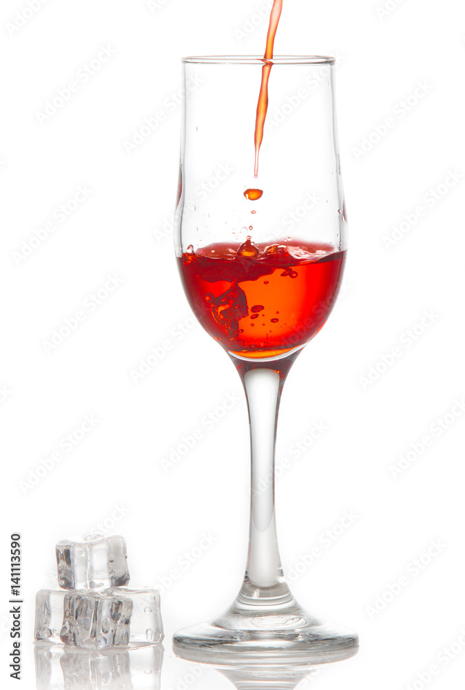 Red wine is poured into a glass On a white background Red wine is poured into a glass On a white background
