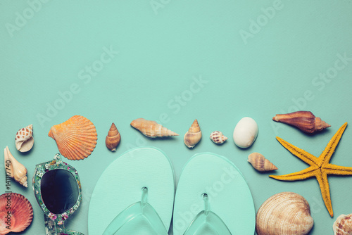 Flip flops; seashells on blue background. Copy space for your text.