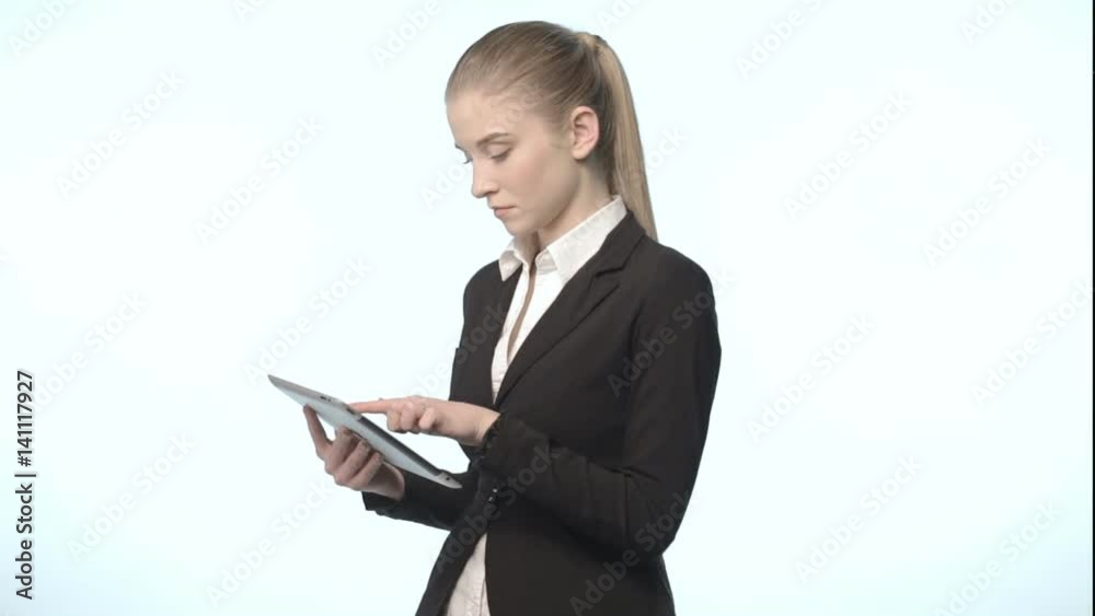 An attractive woman in a business suit with tablet An attractive woman in a business suit with tablet