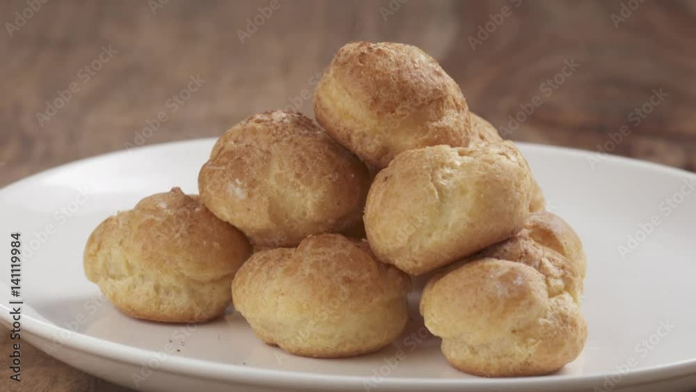 Slow motion of sprinkling cocoa powder over profiteroles, 180fps prores footage Slow motion of sprinkling cocoa powder over profiteroles, 180fps prores footage