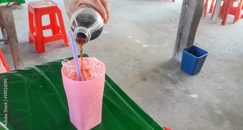 soft drinks are pouring into the glass.Mahasarakham,Thailand,December 2016 photo