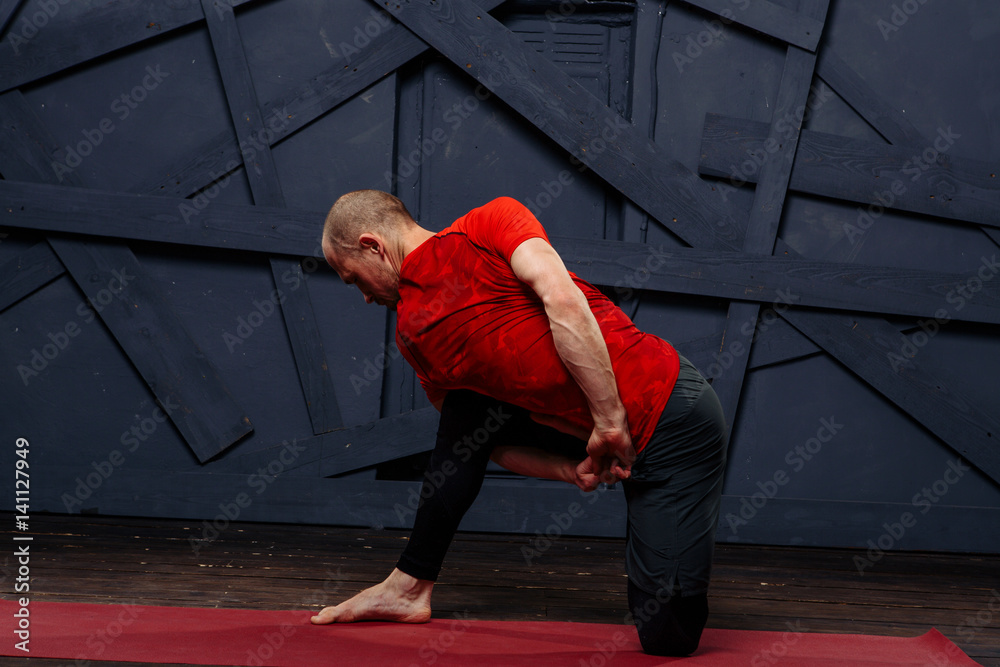 Fototapeta premium Man practicing advanced yoga against a urban background