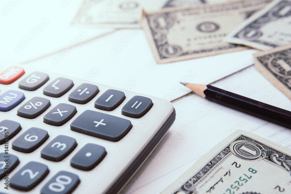 Calculator with american dollars on the wooden table background, finance concept Calculator with american dollars on the wooden table background, finance concept