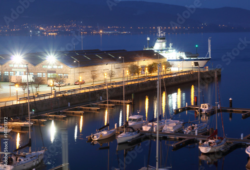 view of a Vigo city marina at sunset with illumination and vessels