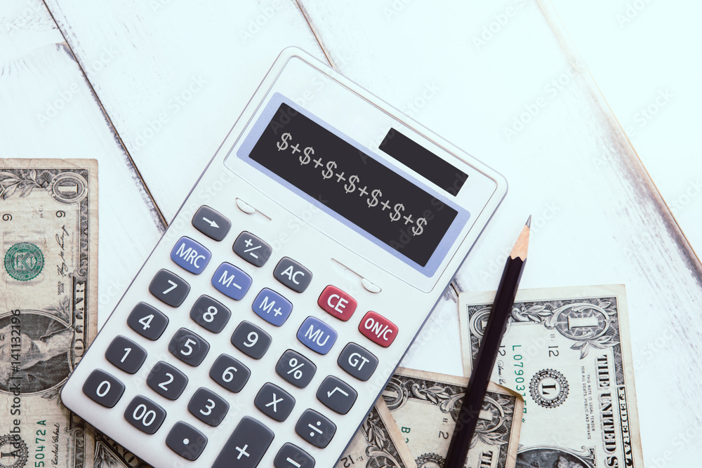 Calculator with american dollars on the wooden table background, finance concept