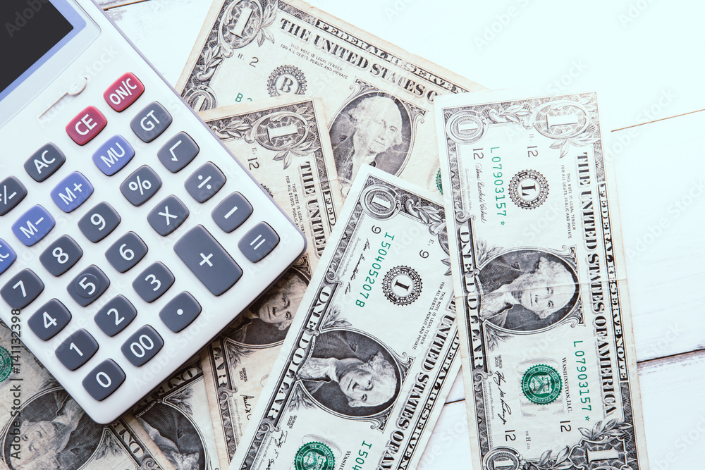 Calculator with american dollars on the wooden table background, finance concept Calculator with american dollars on the wooden table background, finance concept