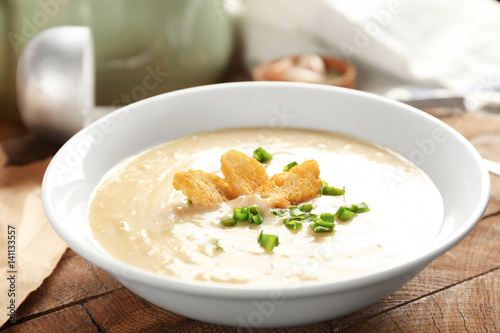 Delicious cream soup with bread on table