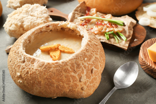 Delicious cream soup in bread on table photo