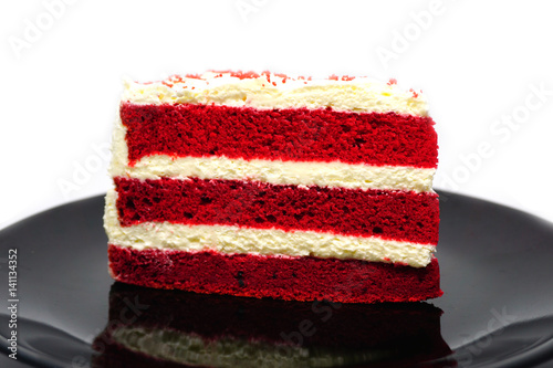Cut cake Red velvet chocolate on black plate isolated on white background