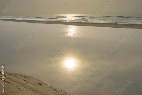 Rising sun reflected in a temporary lagoon at Illovo on the South Coast near Durban
