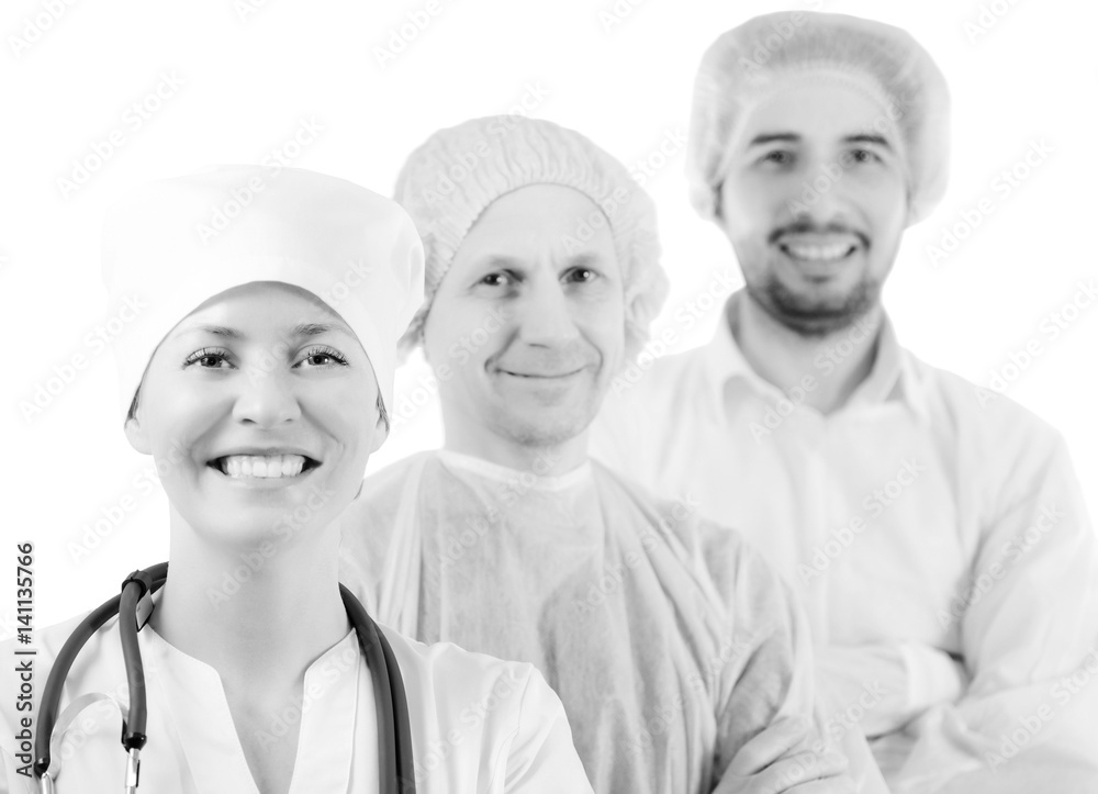 Group portrait of medical doctors in hospital, looking at camera and smiling isolated on white background. Two men wearing surgeon coat and woman wearing white cap and coat. Focus on woman doctor. Group portrait of medical doctors in hospital, looking at camera and smiling isolated on white background. Two men wearing surgeon coat and woman wearing white cap and coat. Focus on woman doctor.