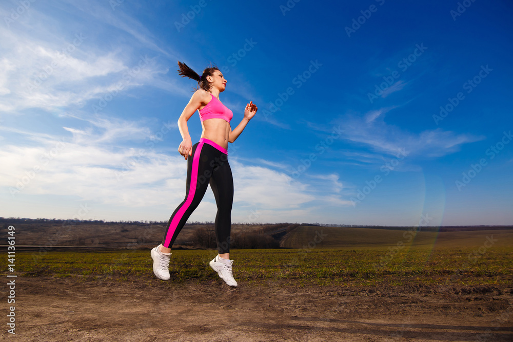 young woman jumping on blue sky background young woman jumping on blue sky background
