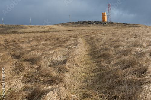 natural grass landscape with lighthouse along the coast of Iceland