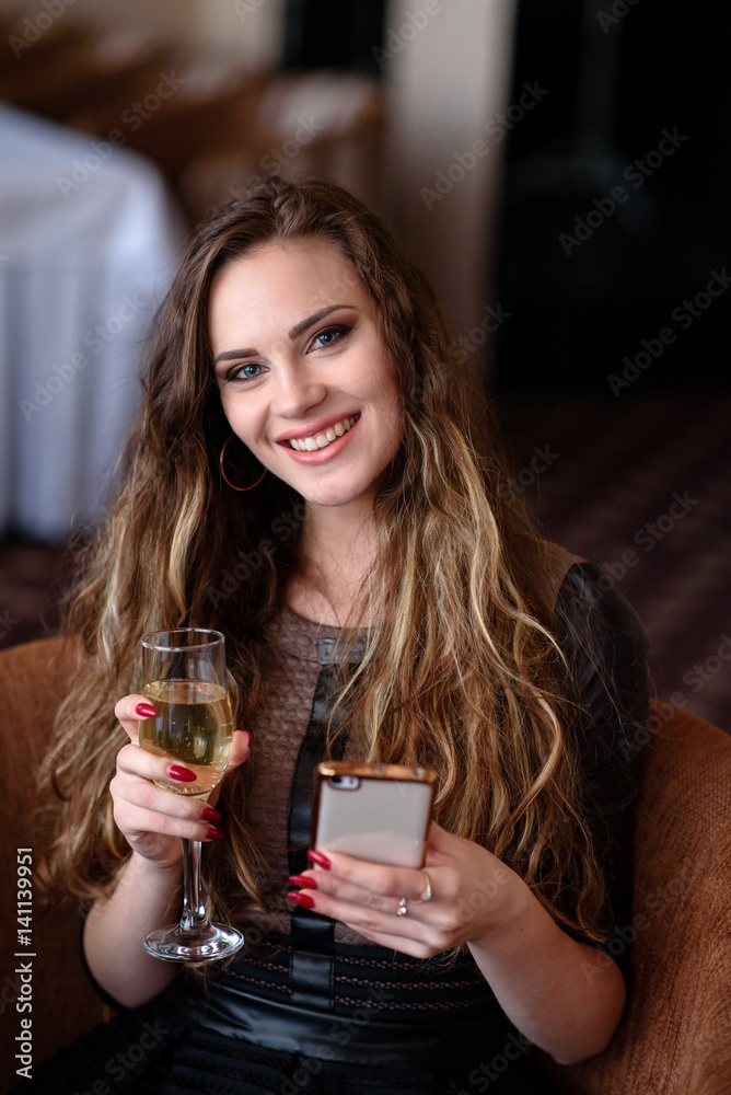 Beautiful girl with a phone and a glass of champagne. Beautiful girl with a phone and a glass of champagne.