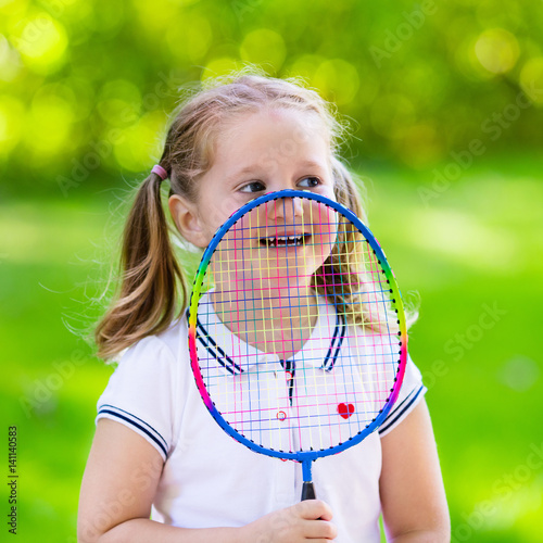 Child playing badminton or tennis outdoor in summer