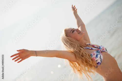 beautiful young woman enjoy on beach with her arms up - success concept