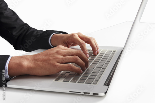 business man is working by using a laptop computer on white table. Hands typing on a keyboard.