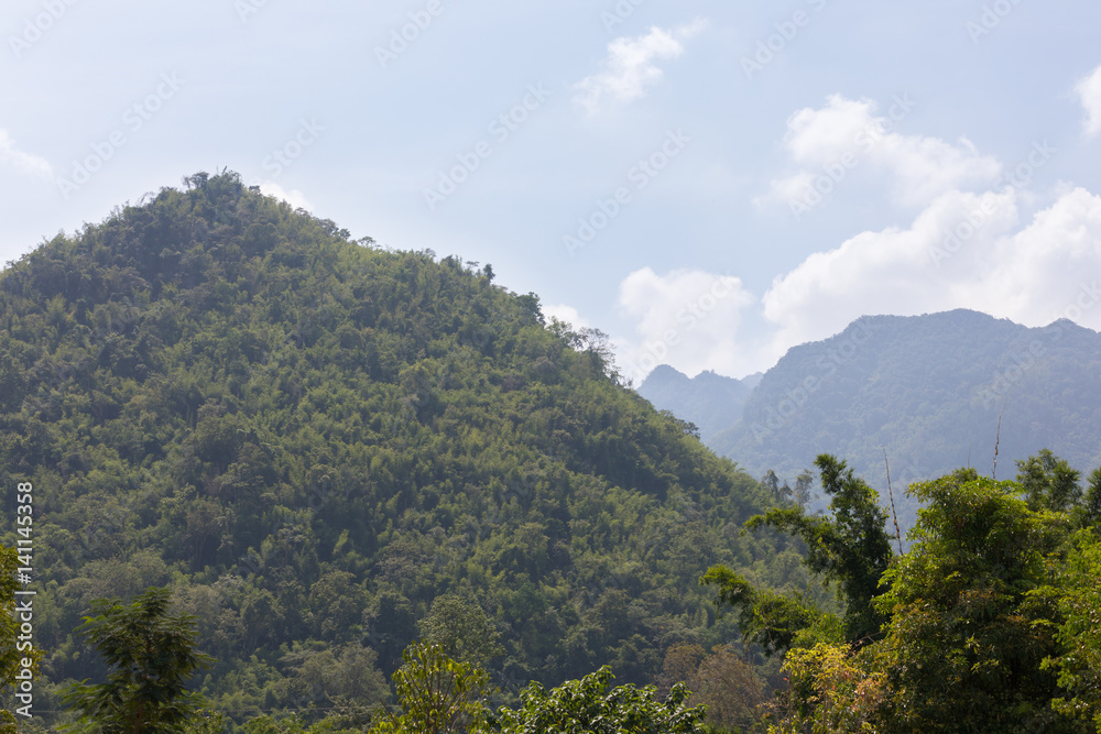 Bright green hill in sunny weather in Thailand