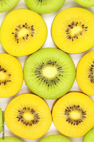 slices of fresh green and yellow kiwi fruits food background texture
