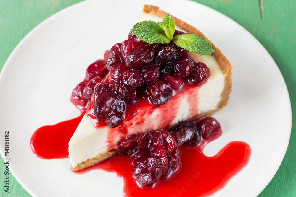 Cheesecake with cherry sauce on white plate, closeup view Cheesecake with cherry sauce on white plate, closeup view