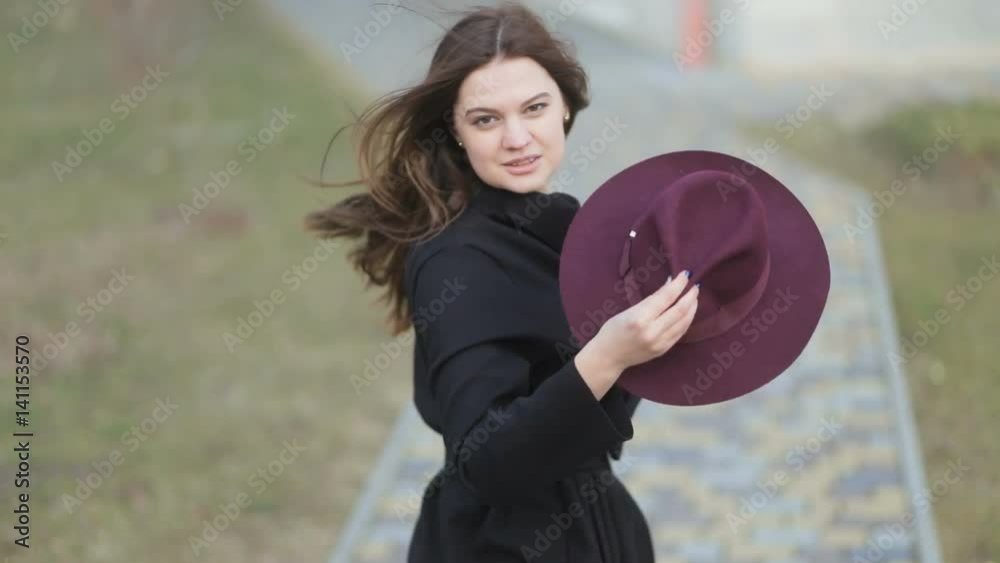 Attractive model walks away, looking back to camera, long hair, autumn coat. Steadicam, slow mo shot Attractive model walks away, looking back to camera, long hair, autumn coat. Steadicam, slow mo shot
