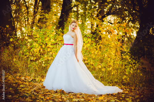 Beautiful bride walking near old castle before wedding ceremony