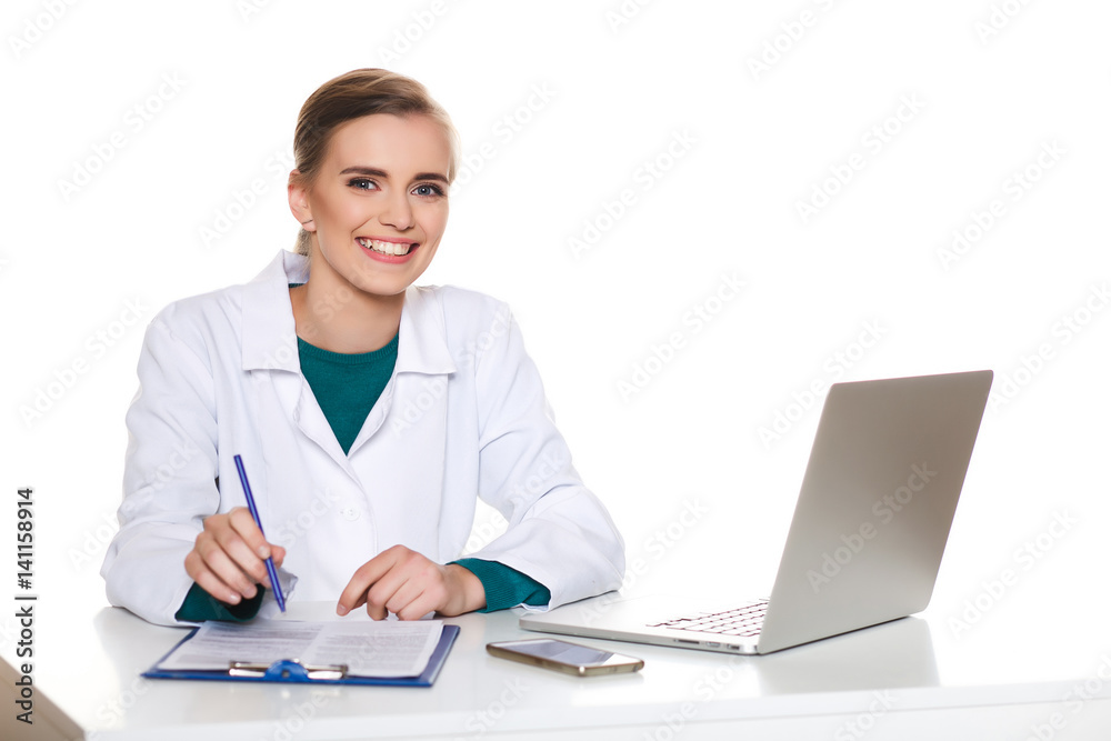 Young female student doctor sitting with a laptop on a white background Young female student doctor sitting with a laptop on a white background