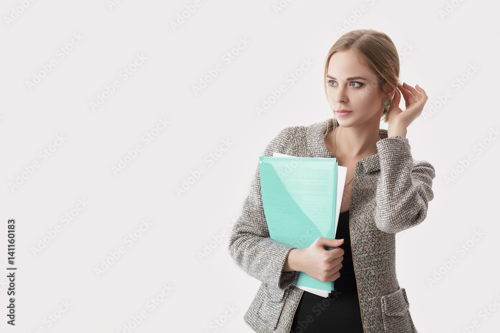 young beautiful business woman in black dress, jacket holding folder of papers and smiling on gray background young beautiful business woman in black dress, jacket holding folder of papers and smiling on gray background
