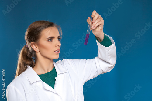 female chemist with a test tube on a blue background