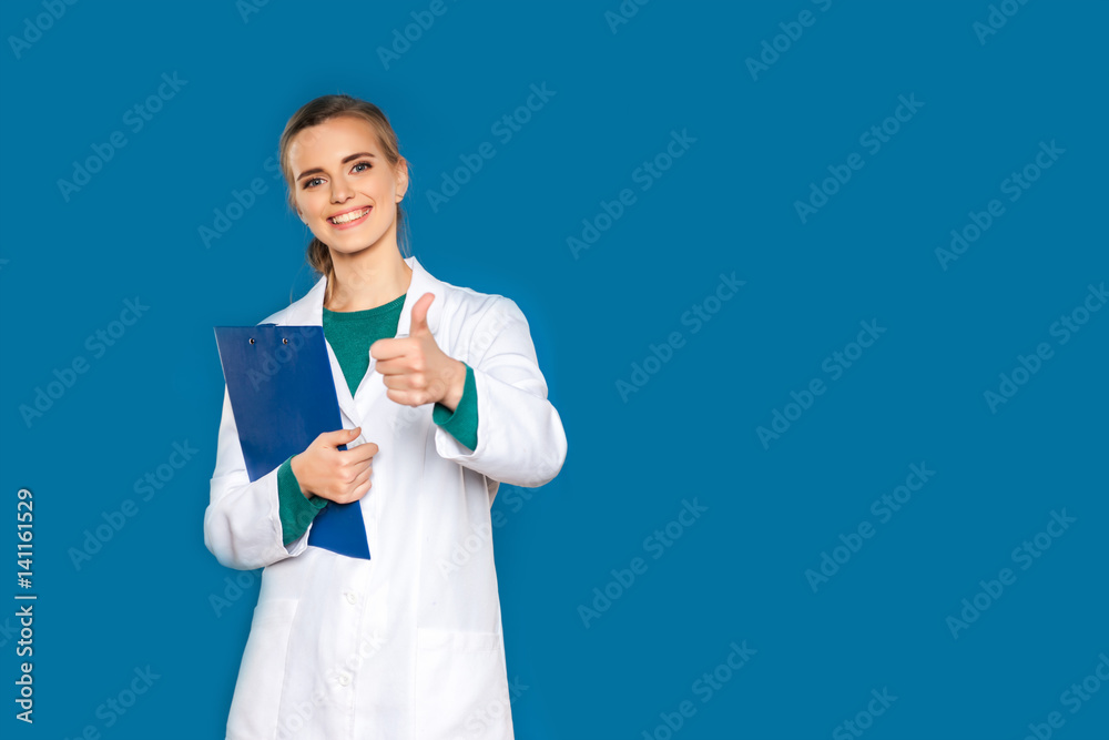Young female student doctor with a tablet on a blue background showing signs Young female student doctor with a tablet on a blue background showing signs