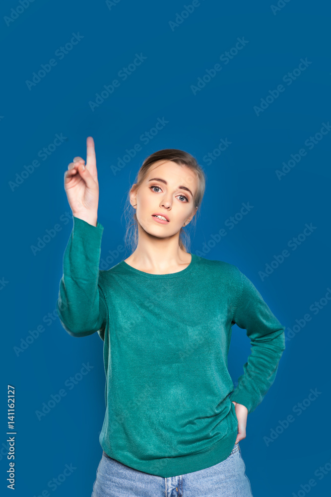 Young woman on a blue background showing signs Young woman on a blue background showing signs