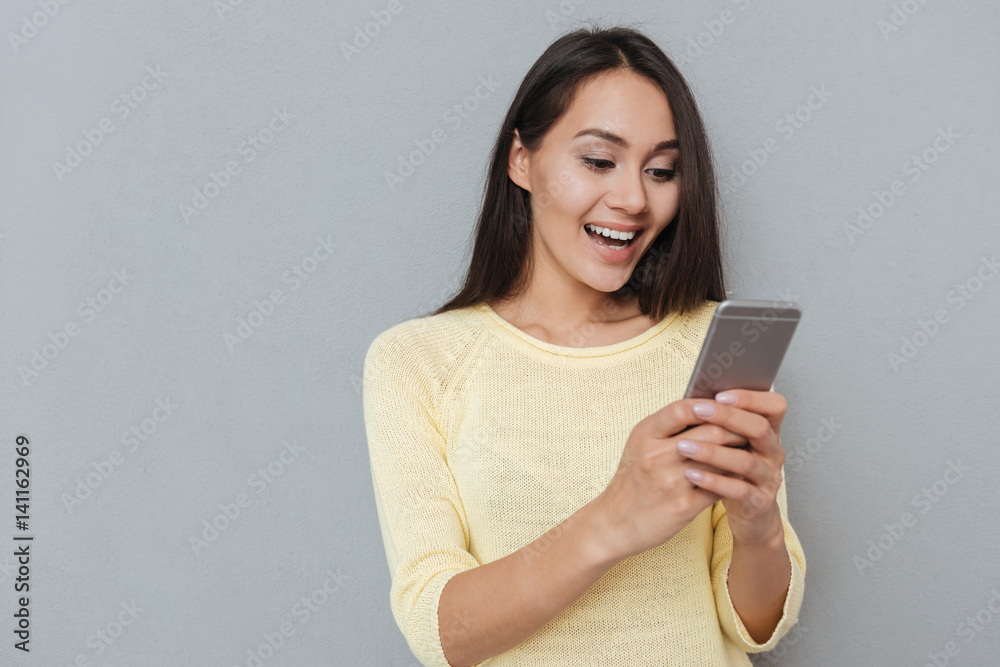 Smiling woman in sweater using smartphone Smiling woman in sweater using smartphone