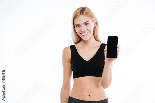 Happy fitness woman showing mobile phone display.