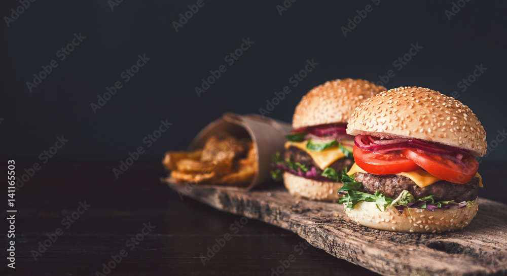 two mouth-watering, delicious homemade burger used to chop beef. on the wooden table.