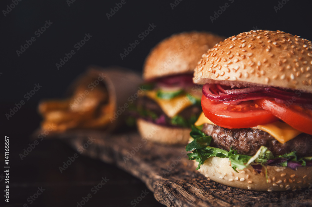 two mouth-watering, delicious homemade burger used to chop beef. on the wooden table. - obrazy, fototapety, plakaty 