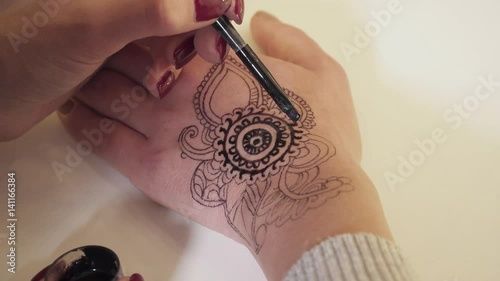 Closeup of the mehendi creation process with a paint brush photo