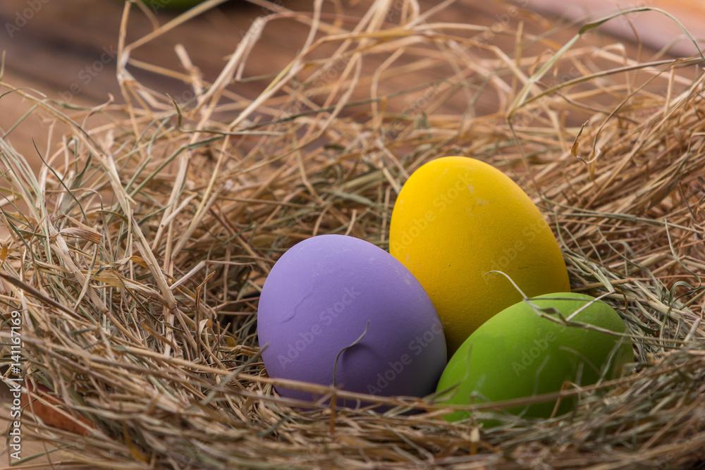 Easter eggs in nest on old wooden background