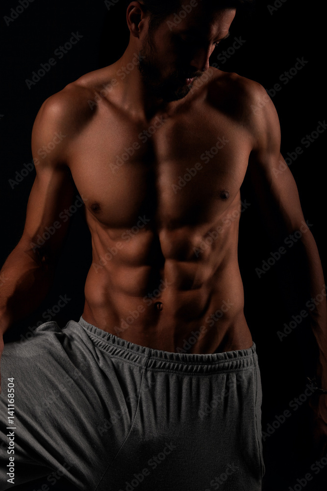 Muscular and defined six pack abs on attractive male model Muscular and defined six pack abs on attractive male model